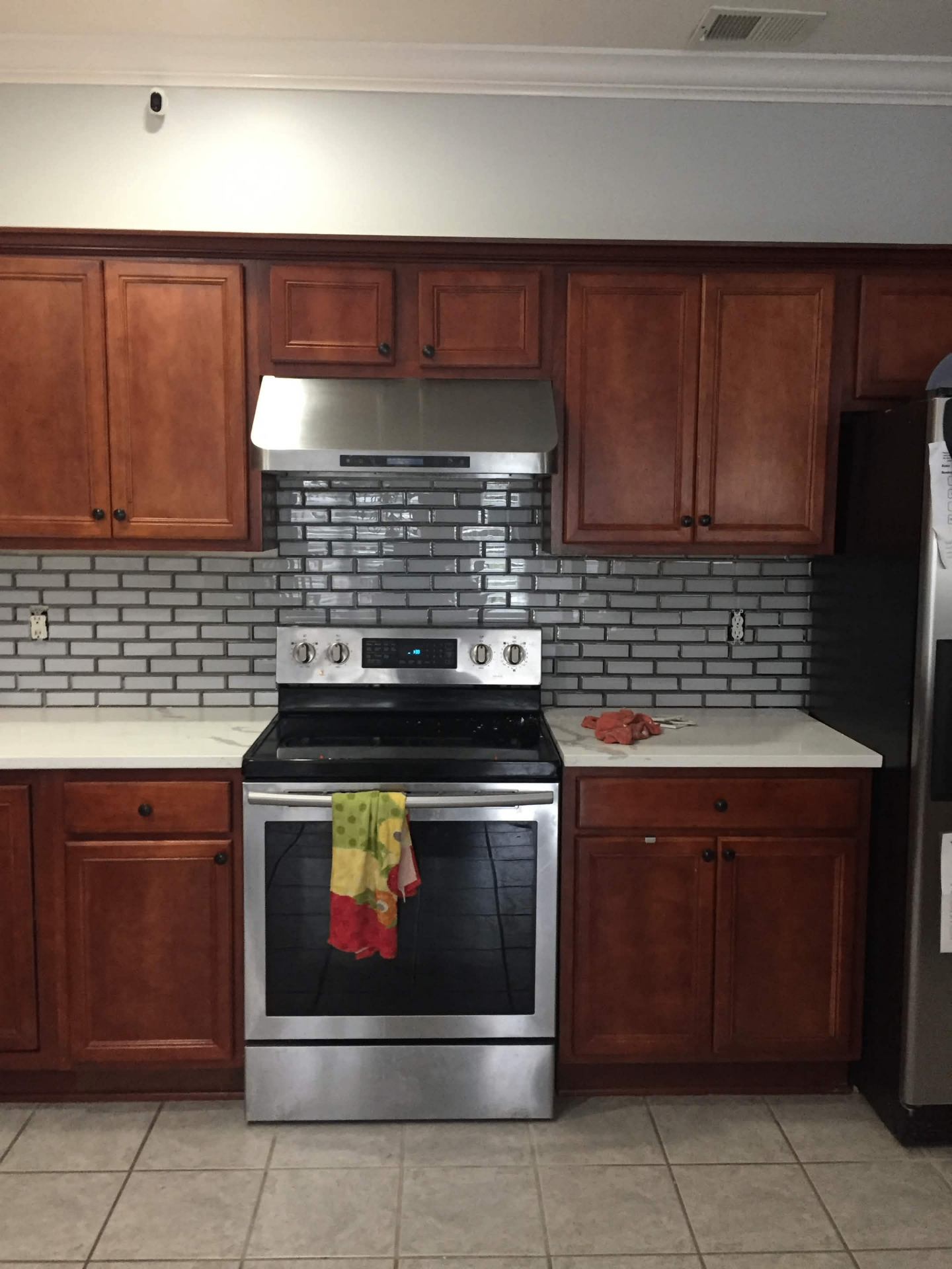 Kitchen with new glass tile backsplash installed behind the range