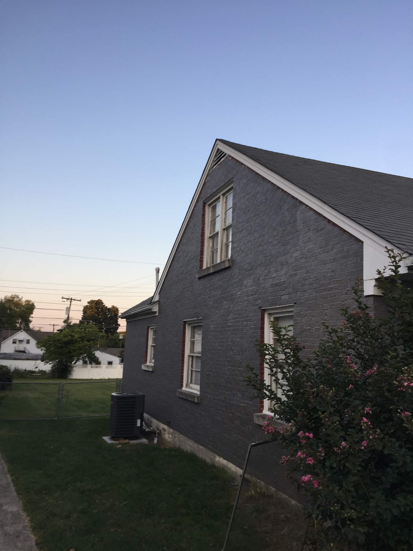 Same brick house repainted charcoal with fresh white trim